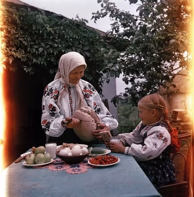 Bé gái và bữa sáng với trứng, sữa, hoa quả. Ảnh chụp tại một ngôi làng ở Ukraine.