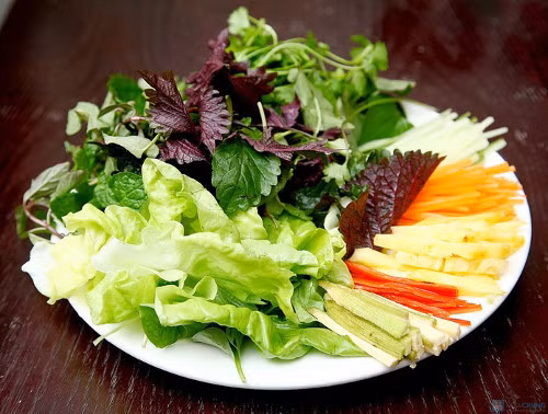 Ăn kèm bánh hỏi lòng heo còn có bánh tráng mỏng và rau sống. Bánh tráng thường được phơi sương hoặc ủ lá chuối để tăng độ dẻo dai. Rau sống ăn kèm thường là húng lũi, xà lách, tía tô, quế, ớt xanh…Ảnh: vietq