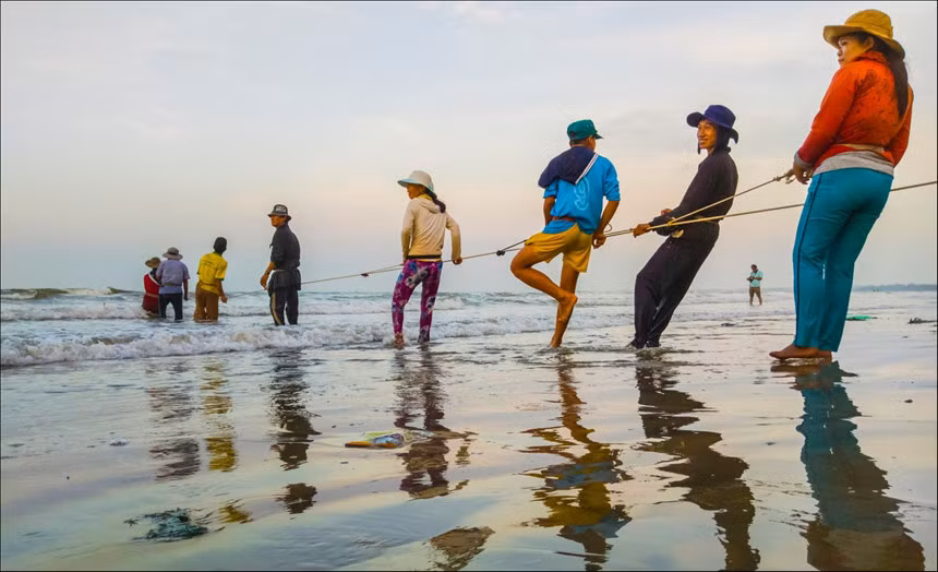 Khoảnh khắc bà con làng chài kéo lưới lúc bình minh vừa lên. Mọi người hăng say lao động và luôn ngập tràn hy vọng có mẻ lưới như mong đợi. Với đường bờ biển dài hơn 1 km và sóng yên gió lặng quanh năm, tàu bè nơi đây hoạt động rất nhộn nhịp, nghề đánh bắt hải sản phát triển. Ảnh: Trần Phương.