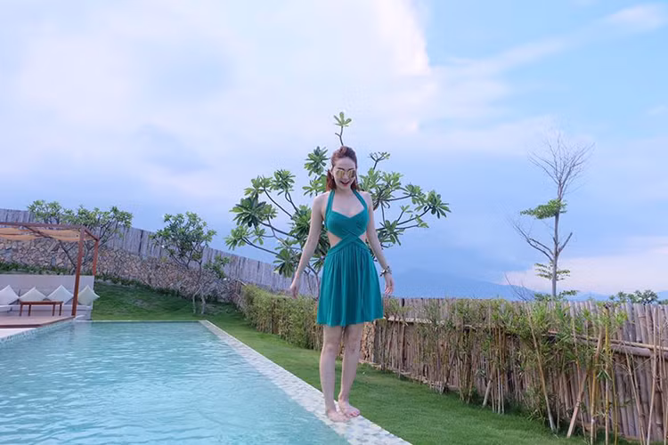Bên bể bơi, Minh Hằng khoe vóc dáng ngọc ngà trong bộ váy xanh cut-out.