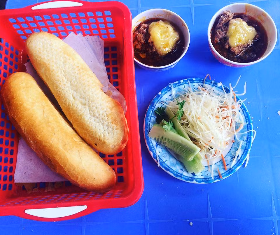 Bánh mì chấm. 5 - Một trong những món ăn vỉa hè nổi tiếng ở Quy Nhơn (Bình Định) là bánh mì chấm. Món bánh mì để nguyên ổ, xé từng miếng quết với nước sốt pate trộn với sốt mayonnesaie, bơ và ăn kèm với một ít rau tươi, đồ gỏi chua. Xé miếng bánh mì nóng thơm bột chấm với nước sốt pate béo ngậy, hương vị này đã đi vào tiềm thức của rất nhiều du khách.
