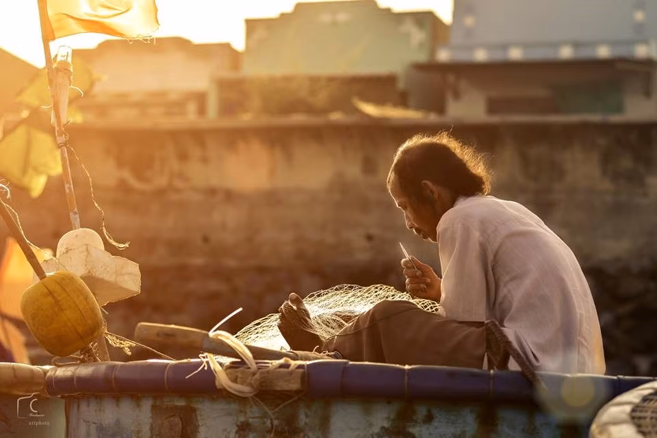 Ngư dân tranh thủ vá lưới sẵn sàng cho buổi đánh bắt vào sáng hôm sau.