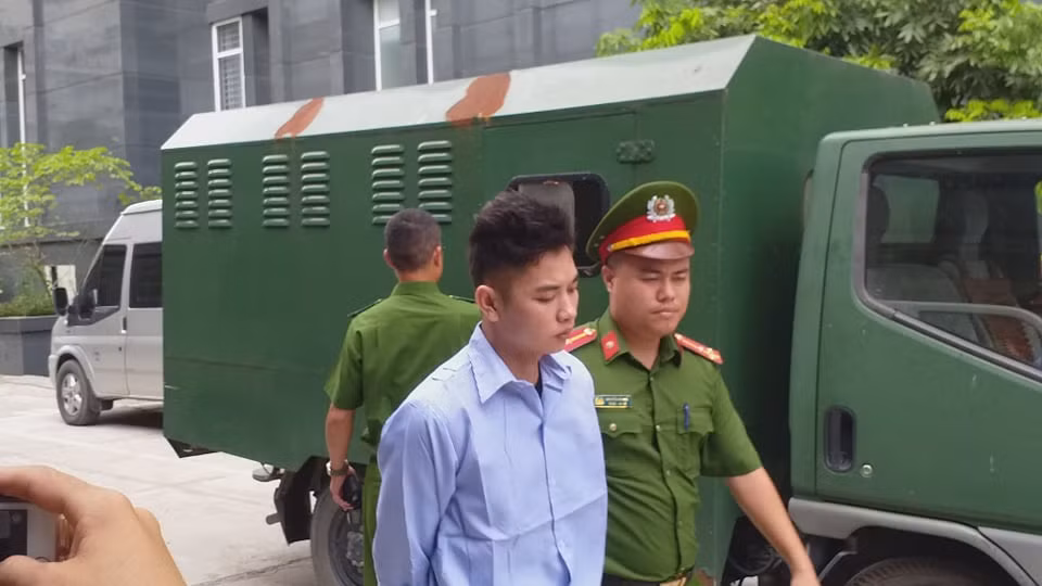 Cơ quan công an giải hai bị cáo đến phòng xét xử.