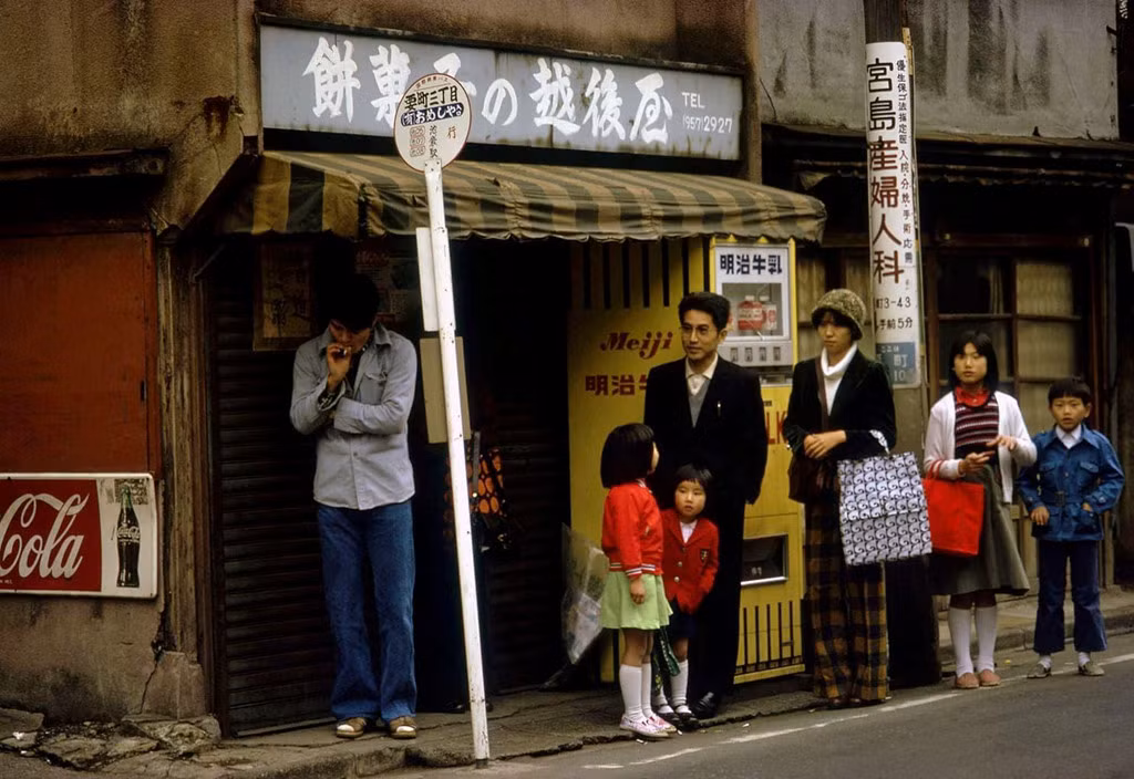 Người dân Tokyo đứng chờ tại một trạm xe buýt ở thành phố. Ảnh: Greg Girard.