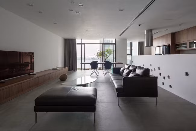 Cặp vợ chồng trẻ mua hai căn hộ với cùng diện tích là 93m2, thiết kế giống hệt nhau, nằm 2 tầng liên tiếp là 12 và 12a, trong một tòa nhà cạnh Hồ Tây. Họ đã biến 2 căn hộ tại hai tầng khác nhau thành một biệt thự 2 tầng. Tầng một là không gian sinh hoạt chung cho cả gia đình và là phòng khách của căn “biệt thự” này.