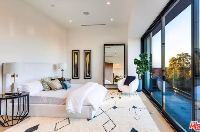 Phòng ngủ chính với những tấm cửa kính rộng lớn giúp nhận nhiều ánh sáng tự nhiên, đón ánh bình minh với cảnh sắc Los Angeles.
