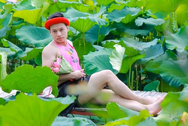 Trước đó, nam thanh niên thân hình cơ bắp, mặc yếm hồng tạo dáng bên hồ sen nhận phải hàng loạt bình luận gay gắt từ dân mạng. Nhân vật chính trong bức hình là Trần Hoàng Sơn (24 tuổi, Bắc Giang). Sơn cho biết, cậu cùng nhiếp ảnh gia chỉ chụp trong vòng 30 phút và cảm thấy sản phẩm của mình "khá đẹp", "thành công". Ảnh: Kun Mon.
