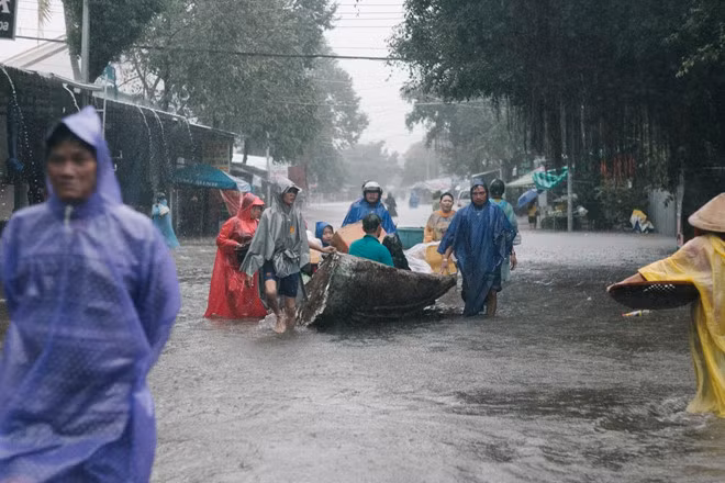 Họ phải đi bộ trong mưa lớn và lội nước ngập sâu, thậm chí dùng thuyền di chuyển.