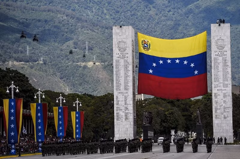 Quốc kỳ Venezuela treo trên cổng chào lớn, phía trên không, phi đội trực thăng bay biểu diễn chào mừng lễ kỷ niệm. Ảnh: Dambiev.livejournal
