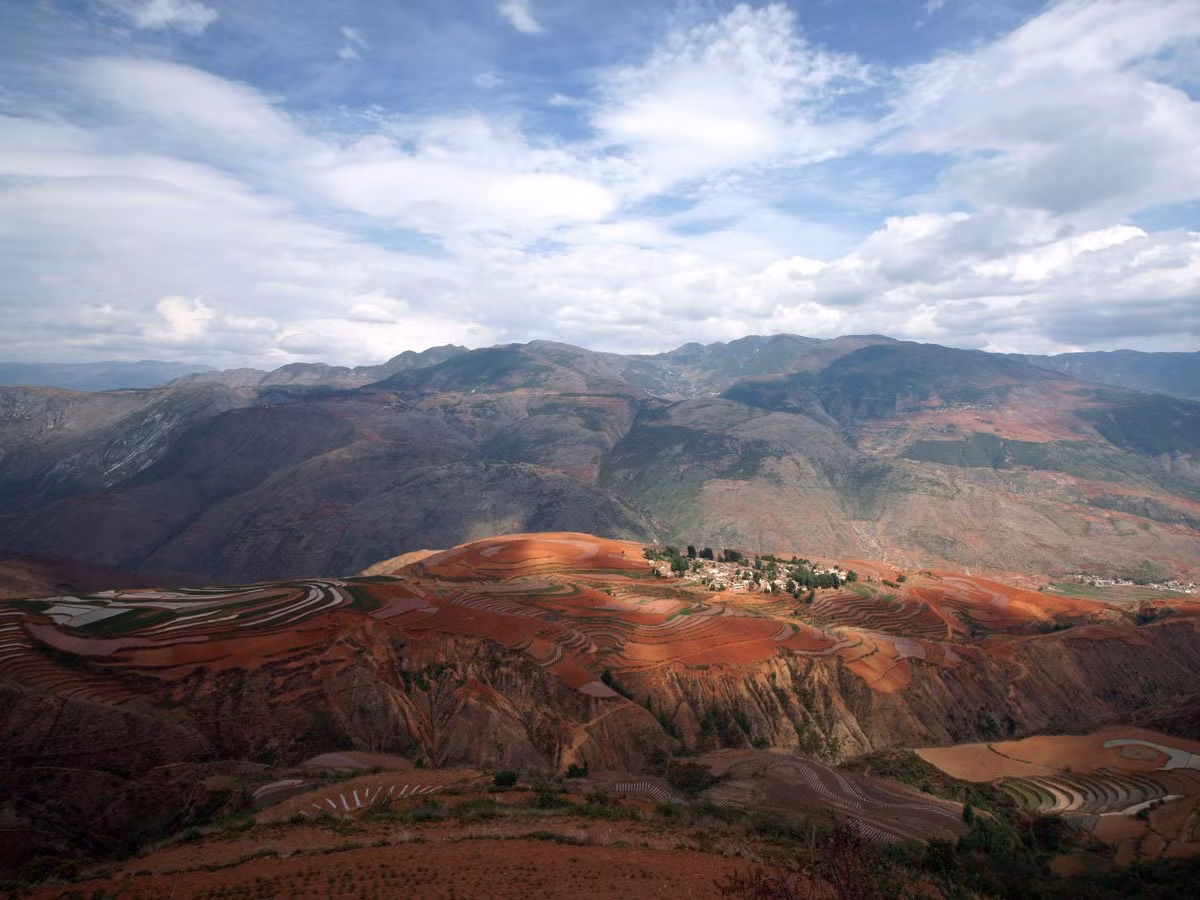 Cánh đồng đỏ Dongchuan nằm ở phía Tây Nam của thành phố Côn Minh là một trong những thắng cảnh nổi tiếng nhất Trung Quốc. Màu đất đỏ tại nơi đây là do khí hậu cận nhiệt đới. Vào khoảng tháng 5 - 6 hoặc tháng 9 - 11 hàng năm, cánh đồng đỏ Dongchuan trở nên nổi bật hơn khi nhiều loại cây khoe sắc rực rỡ.