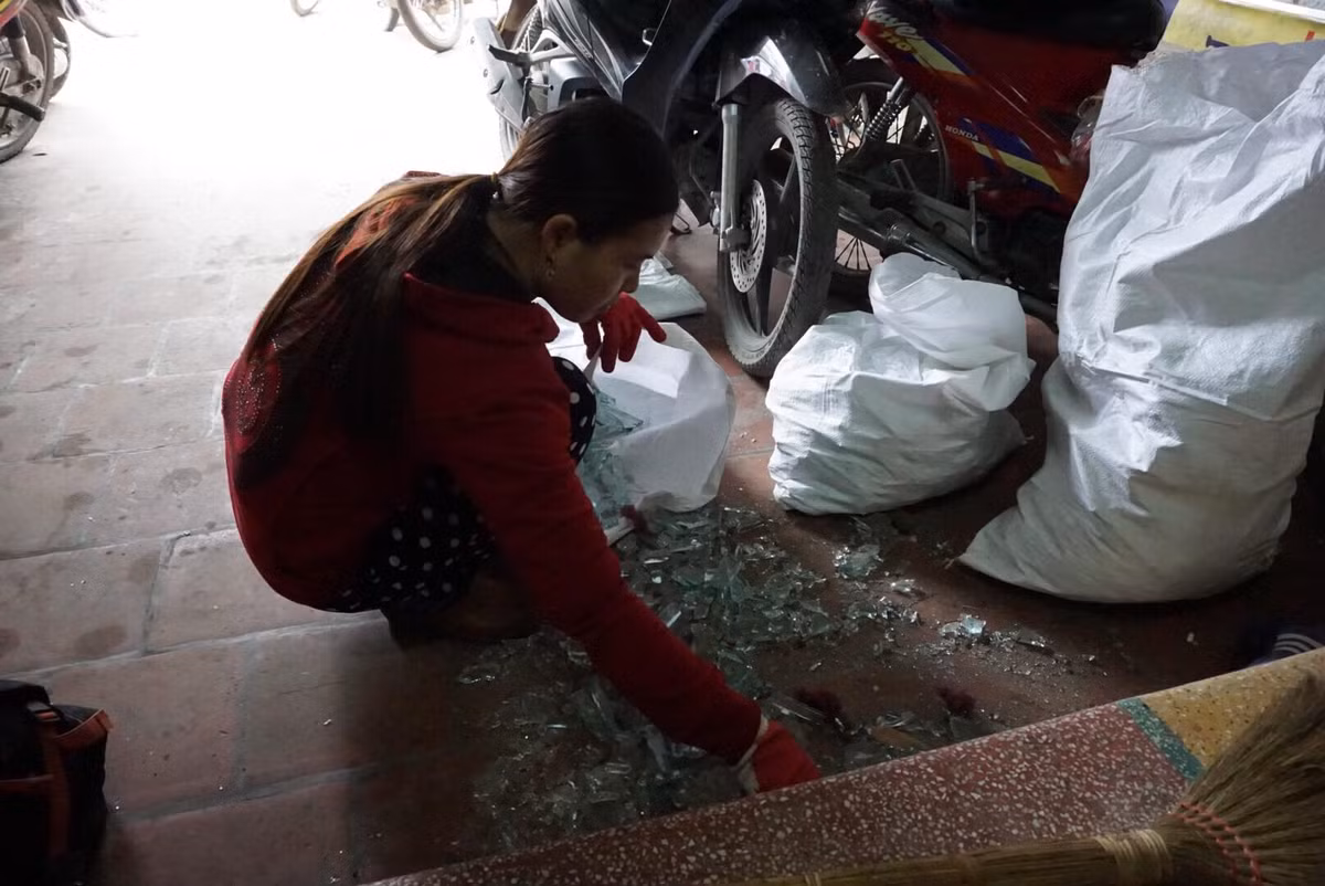 Người dân thu gom lại những mảnh kính vỡ.