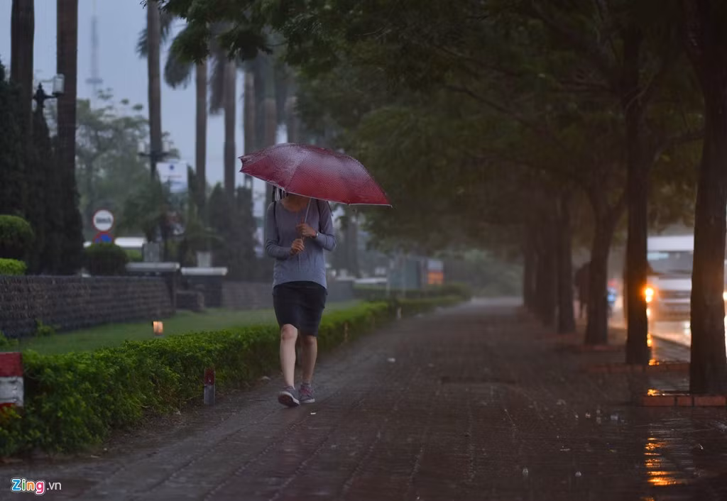 Nhiều người vội vã mặc áo mưa và bật ô.