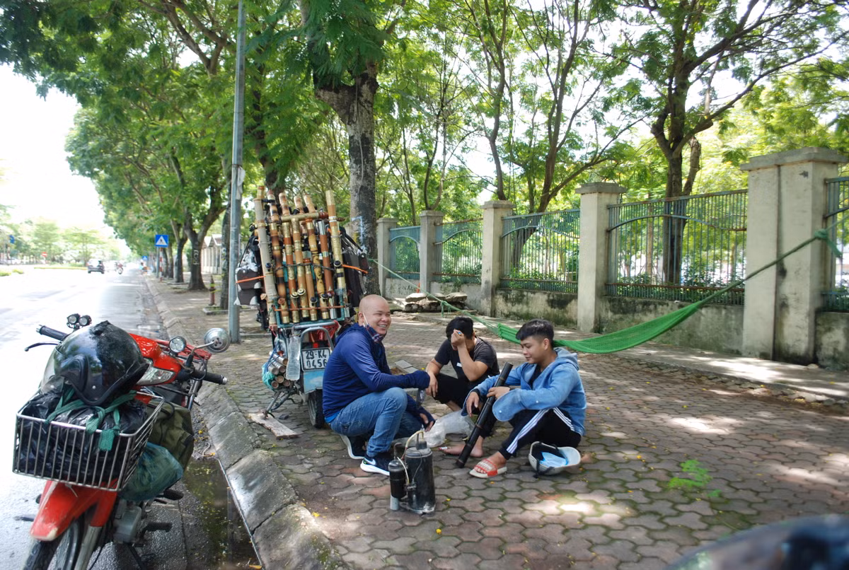 Người lao động tránh nắng buổi trưa dưới những tán cây xanh.