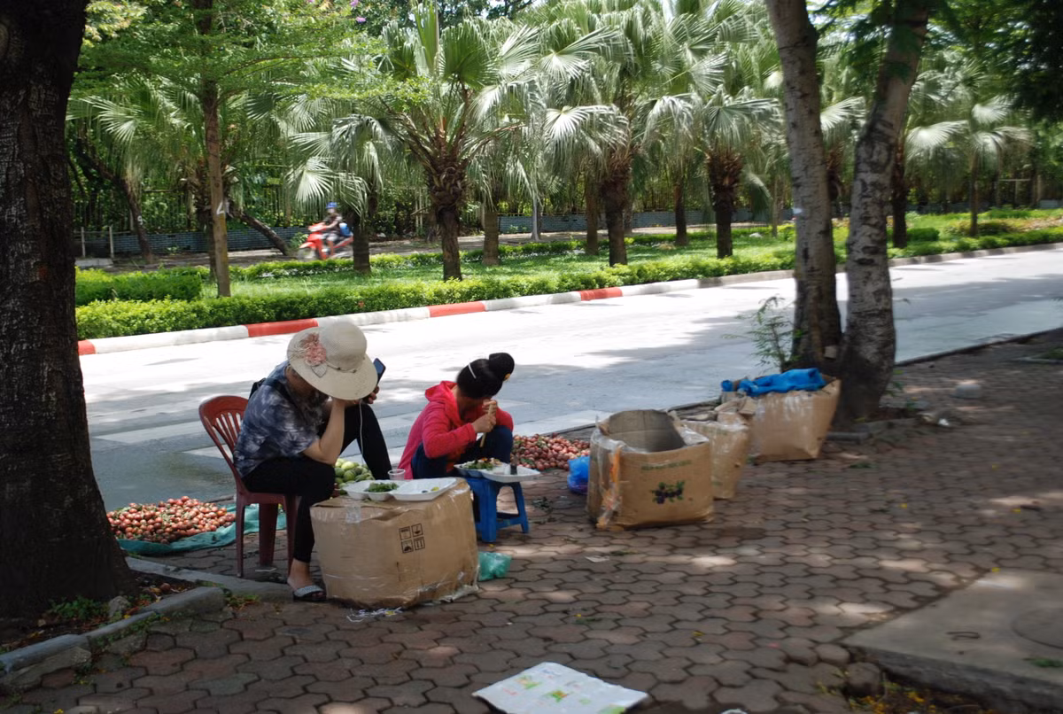 Bữa cơm đạm bạc của người dân lao động tự do bên hàng cây xanh mát rượi trên phố Tân Mỹ, phường Mỹ Đình, Nam Từ Liêm, thành phố Hà Nội.
