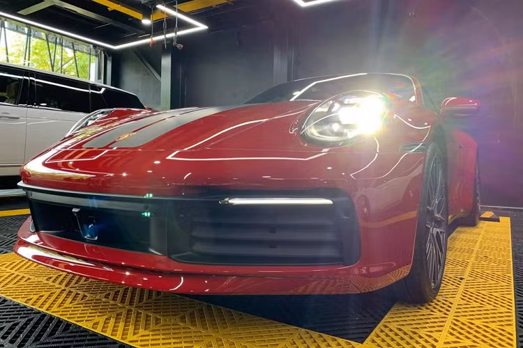 Tiến vào bên trong khoang lái chiếc xe thể thao mui trần Porsche 911 Carrera S Cabriolet thế hệ mới sắp được bàn giao cho đại gia lan đột biến có nội thất màu đỏ rất "sexy" và tông xuyệt tông với màu sơn ngoại thất của xe được chủ nhân lựa chọn. Xe có vô-lăng bọc da Alcantara cao cấp