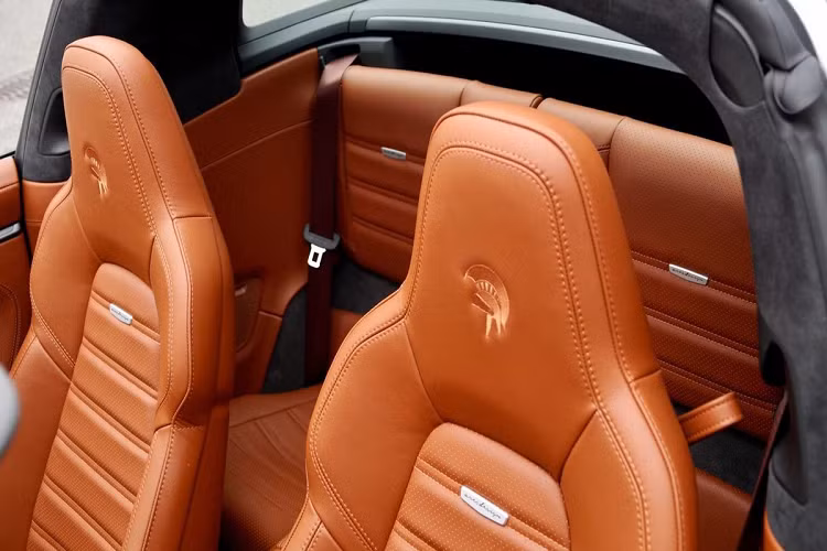 Ares Design độ Porsche 911 Targa sử dụng các chất liệu da cao cấp tại khu vực nội thất. Tựa đầu và vô lăng được thêu nổi logo vị thần chiến tranh - tên gọi của hãng độ này.