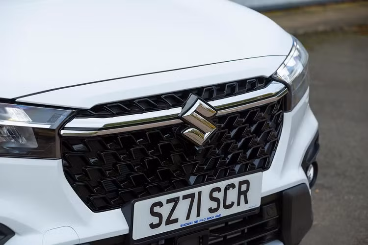 Trên đầu xe, Suzuki SX4 S-Cross 2022 được trang bị lưới tản nhiệt màu đen bóng và nắp ca-pô cao hơn. Bên trong lưới tản nhiệt cỡ lớn hơn còn có nẹp mạ crôm dày dặn, nối liền với logo của hãng Suzuki. Hai bên lưới tản nhiệt là cụm đèn pha hoàn toàn mới, được chia thành 2 tầng nhờ nẹp mạ crôm bên trong. Nửa trên là dải đèn LED định vị ban ngày trong khi bên dưới là đèn pha Matrix LED vừa hiện đại vừa gọn gàng hơn trước.