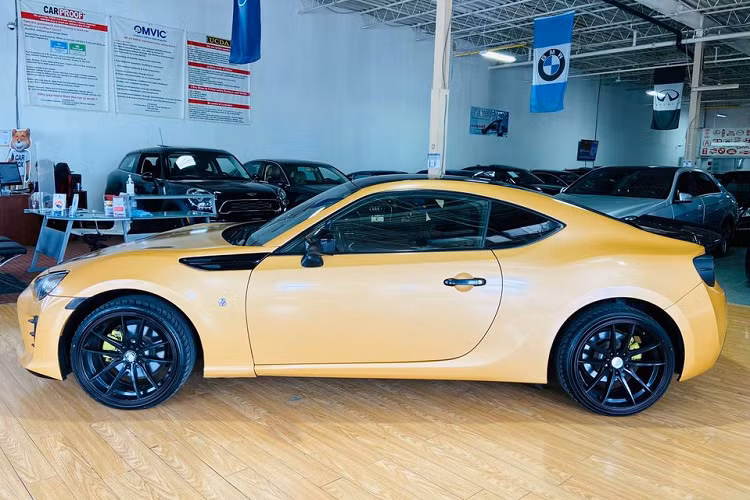 Về ngoại hình, chiếc Toyota 86 nhái Lamborghini này được phủ lớp decal màu vàng tương tự những mẫu siêu xe Lamborghini, một vài chi tiết như khe hút gió hay nóc xe vẫn được giữ màu sơn đen nguyên bản. Bộ mâm màu đen bóng có kích thước 18 inch, ẩn phía trong là kẹp phanh được sơn màu vàng chanh nổi bật.
