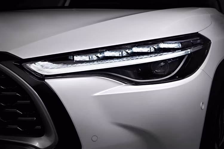 Bên ngoài, mẫu xe SUV Toyota Corolla Cross 2022 sở hữu thiết kế ngoại thất như sự kết hợp giữa xe ở Việt Nam và Nhật Bản. Theo đó, xe cũng được trang bị lưới tản nhiệt trên cỡ lớn với viền màu bạc và màu đen xung quanh. Bên dưới là hốc gió trung tâm khá rộng, tích hợp 2 đèn sương mù nhỏ hình tròn. Ngoài ra, hốc gió trung tâm còn được bao quanh bằng nẹp màu đen dày dặn, giúp tách riêng chi tiết này và lưới tản nhiệt. Những chi tiết này không có gì khác so với xe ở Việt Nam.