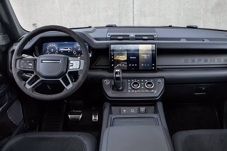 Tương tự ngoại thất, cabin của Defender 2022 không có thay đổi thiết kế. Khoang lái vẫn mang phong cách lấy cảm hứng từ các mẫu xe quân đội với vô-lăng 4 chấu, khu vực điều khiển trung tâm tối giản, bảng tablo tạo hình theo phương ngang với nhiều ngăn chứa đồ.
