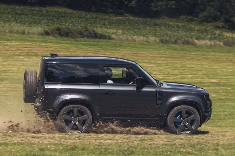 So với những phiên bản thấp hơn, Defender V8 sở hữu một diện mạo tinh tế và mạnh mẽ hơn, bao gồm thân xe rắn chắc với các đường gân dập nổi rõ nét, huy hiệu Land Rover nằm ngay sau cột C và ống xả quad tích hợp trên cản va sau. Tiếng gầm uy lực của động cơ V8 khi khởi động là manh mối rõ ràng nhất cho thấy đây không phải là một chiếc Defender thông thường. 