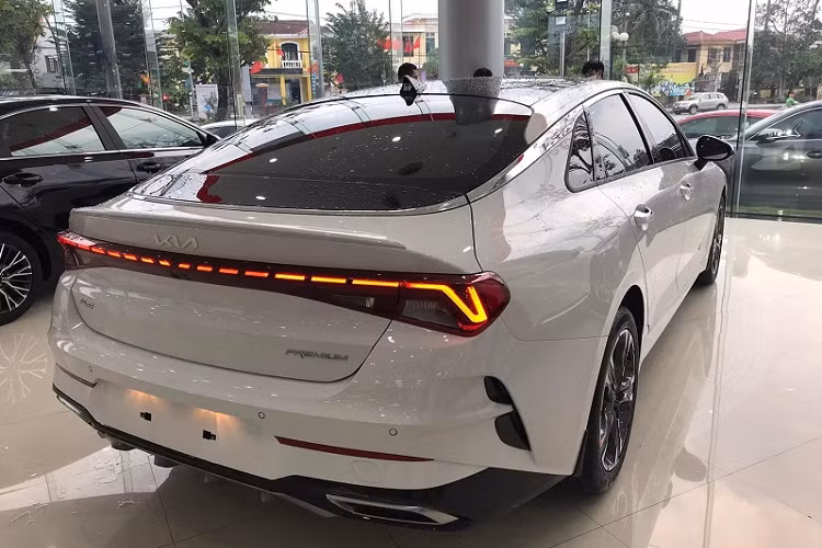 Kia K5 GT-Line 2022 mới đang có mặt tại đại lý được trang bị bộ la-zăng 5 chấu kép cỡ 18 inch thiết kế thể thao. Xe còn có gương chiếu hậu chỉnh điện, gập tự động và tích hợp đèn báo rẽ. Ở khu vực đuôi xe là cụm đèn hậu thiết kế mới với cấu trúc LED đứt đoạn trải dài hết chiều rộng. Ngoài ra phiên bản thể thao này còn có hốc gió dạng vây cá nằm đối xứng hai bên, nắp cốp dập nổi mạnh mẽ, cản va sau tích hợp bộ khuếch tán cơ bắp và ống xả hình thang mạ chrome.