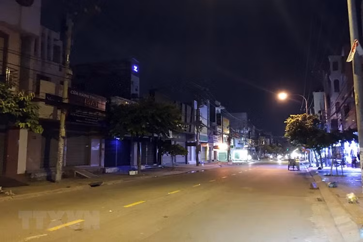 Đường Nguyễn Ảnh Thủ, tuyến đường sấm uất giữa Quận 12 và huyện Hóc Môn trở nên vắng lặng trước giờ giãn cách xã hội. (Ảnh: Tiến Lực/TTXVN) 