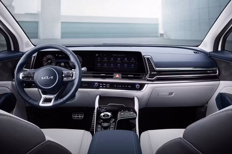 Nội thất của Kia Sportage 2022 chia sẻ phong cách thiết kế từ "đàn anh" Sorento nhưng được làm trẻ trung và năng động hơn. Màn hình kỹ thuật số kép bố trí nghiêng về hướng người lái và liền lạc với cụm điều khiển điều hòa.