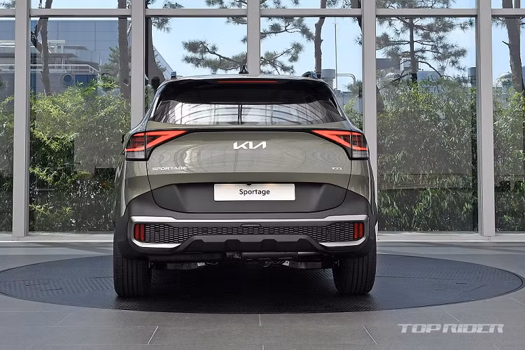 Đằng sau, Kia Sportage thế hệ mới được bổ sung cụm đèn hậu nối liền với nhau bằng nẹp màu đen ở giữa. Bên dưới nẹp này là logo mới của hãng Kia và bộ khuếch tán gió màu bạc, kéo dài sang hai bên, bao quanh đèn phản quang nằm ngang. Ngoài ra, Kia Sportage 2022 tại thị trường Hàn Quốc còn có bản Gravity cao cấp nhất với thiết kế thể thao hơn. Được gọi bằng cái tên X Line ở thị trường châu Âu, bản Gravity này đi kèm cản va trước/sau hầm hố hơn, thanh ba-bô-lê bên sườn và baga nóc nổi bật hơn.