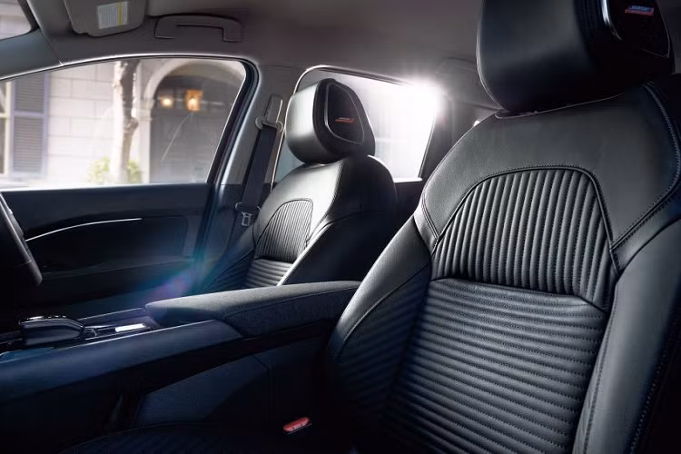 Trên đầu xe, Nissan Note Aura 2022 được trang bị cụm đèn pha thanh mảnh giống Ariya. Bên trong mỗi đèn pha là 4 bóng LED được xếp nằm ngang. Ngoài ra, đèn pha của xe còn được nối với nhau bằng nẹp màu đen bóng ở giữa, nằm ngay trên lưới tản nhiệt có mắt lưới hình kim cương mới. So với Note thông thường, Nissan Note Aura 2022 có thiết kế đầu xe trông liền lạc hơn.