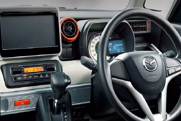 Bên trong Mazda Flair Wagon 2022 là không gian nội thất 2 hàng ghế. Xe được trang bị vô lăng 3 chấu tích hợp phím chức năng, màn hình đa thông tin nhỏ trong bảng đồng hồ, màn hình thông tin giải trí nằm độc lập trên mặt táp-lô và màn hình hiển thị thông tin kính lái. Hệ thống điều hòa của xe cũng đi kèm một màn hình nhỏ, nằm giữa 2 nút chỉnh dạng cơ.