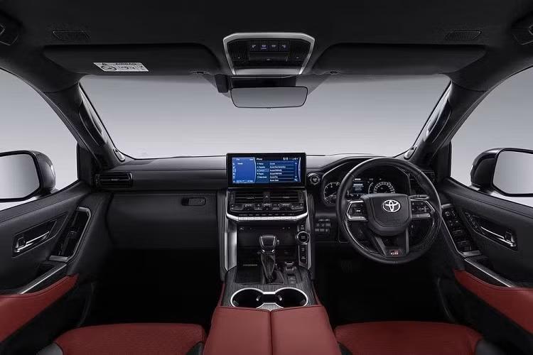 Trên lưới tản nhiệt còn có tem chữ "Toyota" màu trắng cỡ lớn và nổi bật, nằm giữa 2 nan mạ crôm dày dặn. Bên dưới nan mạ crôm là logo "GR-S" màu đỏ - đen đặc trưng của những chiếc xe thể thao GR Sport. Ngoài ra, Toyota Land Cruiser 300 GR-S 2022 còn được trang bị thiết kế cản trước riêng và tấm ốp gầm màu bạc. Bước vào bên trong Toyota Land Cruiser 300 GR-S 2022, chúng ta sẽ thấy không gian nội thất bọc da màu đỏ - đen tương phản và thể thao hơn thay vì màu be như bản thường.