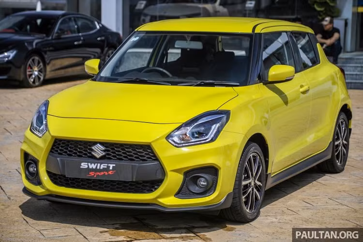 Ngoài ra, ở giữa lưới tản nhiệt của Suzuki Swift Sport 2021 còn có thanh nằm ngang dày dặn với thiết kế giả sợi carbon thay vì nẹp mạ crôm như bản thường. Tương tự như vậy, cánh lướt gió dưới cản trước/sau và bên sườn của xe cũng được thiết kế giả sợi carbon nhằm mang đến vẻ ngoài thể thao cho xe.