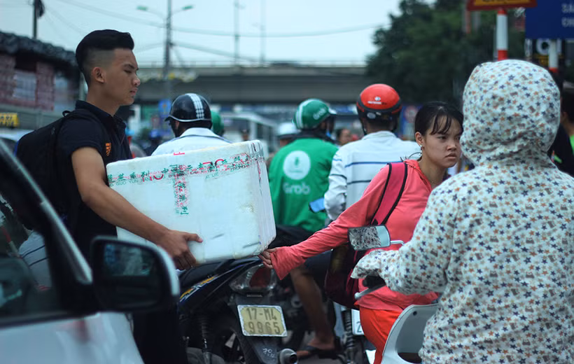 Người dân mang theo nhiều đồ đạc lỉnh kỉnh, phải luồn lách qua các phương tiện ở bến xe Nước Ngầm.