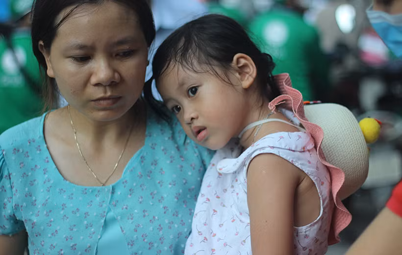 Nhiều em nhỏ vật vờ trên vai mẹ sau khi vượt hàng trăm cây số từ quê lên Thủ đô sau kỳ nghỉ lễ kéo dài.
