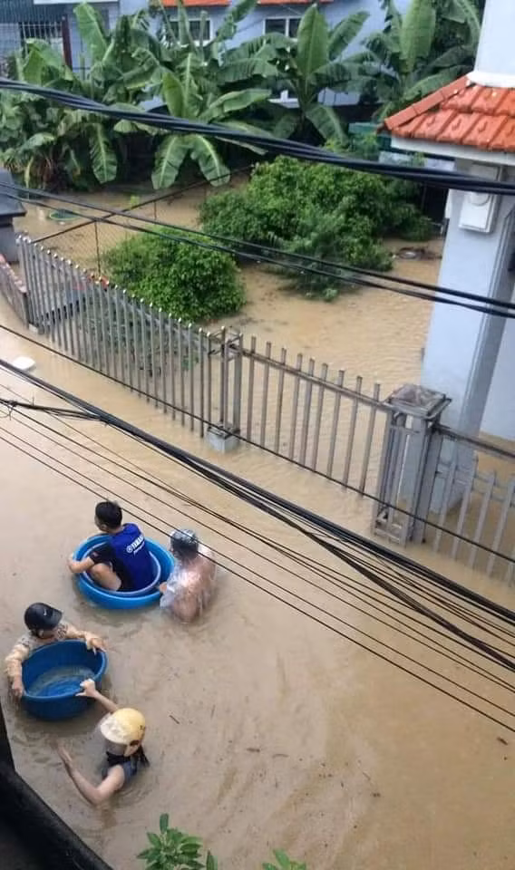 Nhiều người dùng thau chậu để di chuyển do nước ngập ngang ngực người.