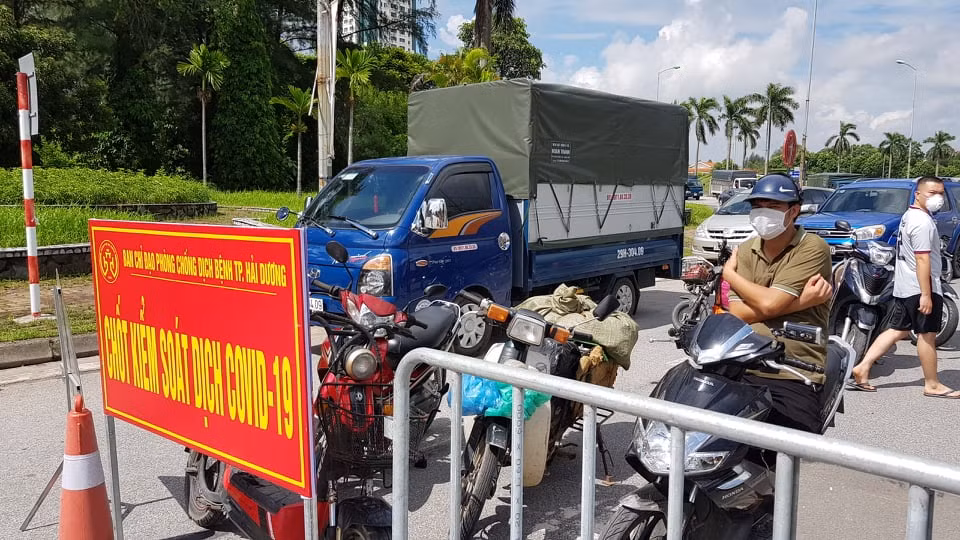 Một người đàn ông đội nắng chờ qua chốt.