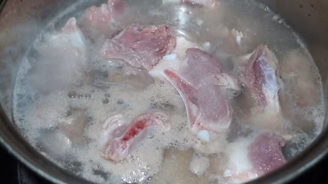 Luộc qua sườn bằng nước sôi. Đun lửa to, đợi nước sôi sẽ thấy có rất nhiều bọt bẩn hiện lên trên mặt nước. Đổ nước luộc này đi, rửa lại sườn cho sạch bọt bẩn và vụn thịt.