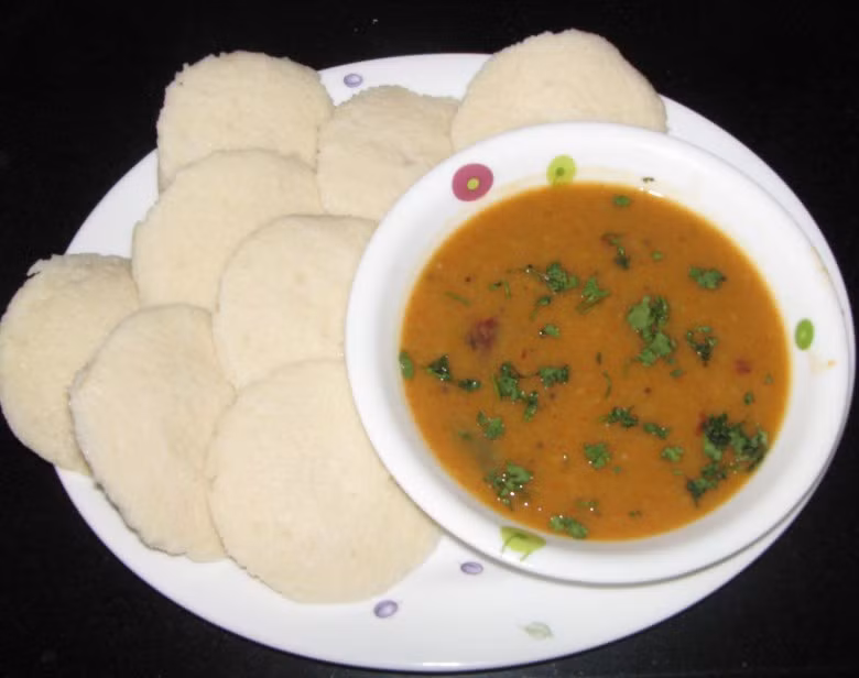 Bánh Idli - Ấn Độ. Idli là tên gọi một loại bánh mặn phổ biến trong các bữa sáng tại Nam Ấn Độ. Chiếc bánh gạo được hấp chín trong những chiếc khuôn tròn nhỏ và sau đó ăn kèm với sambar và tương ớt xoài. Idlis màu sáng và có hương vị êm dịu còn là một loại đồ ăn vặt lý tưởng mỗi khi dạ dày của bạn không chịu được đồ cay.