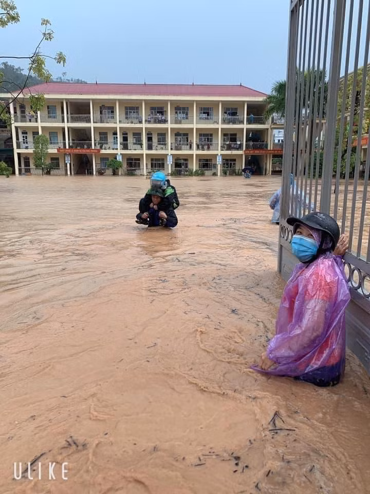 Rất nhiều phụ huynh phải vào tận cửa lớp cõng con ra ngoài. (Ảnh: Pháp Luật và Bạn Đọc)