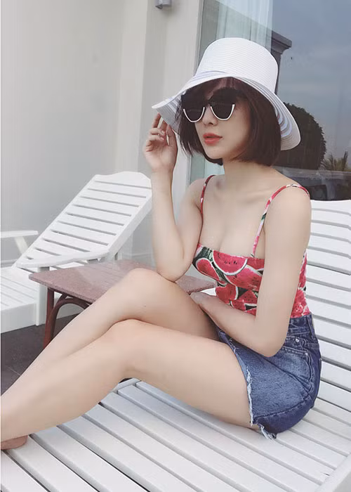 Diệp Lâm Anh khoe vóc dáng nuột nà trong set trang phục gồm áo hai dây kết hợp cùng váy jeans ngắn.