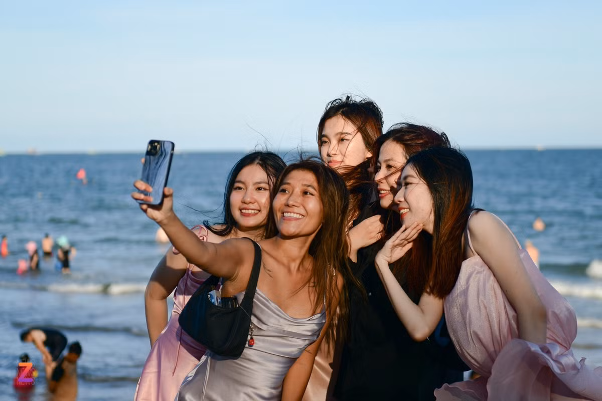 Đến Phan Thiết dự đám cưới, Ánh Linh (áo xám, sống tại TP.HCM) cũng tranh thủ ra biển chụp ảnh. "TP Phan Thiết rất đẹp, nhiều địa điểm du lịch nằm rải rác nên không quá đông đúc. Mặc dù buổi trưa nắng nóng nhưng cảm giác vẫn dễ chịu hơn TP.HCM nhờ có gió biển", Linh nói.