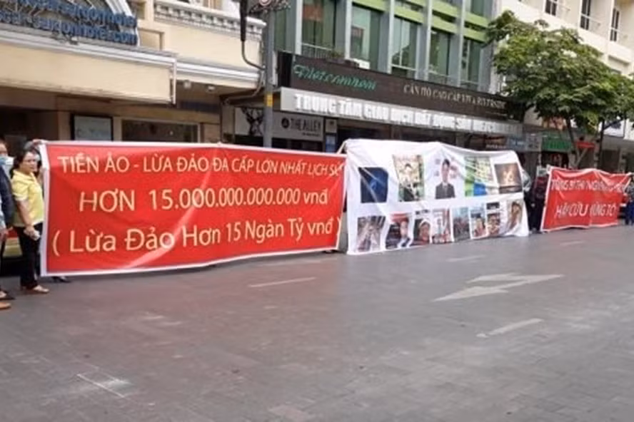 Người dân giăng băng rôn phản ứng việc công ty Modern Tech huy động vốn tiền ảo đa cấp tại trụ sở công ty.
