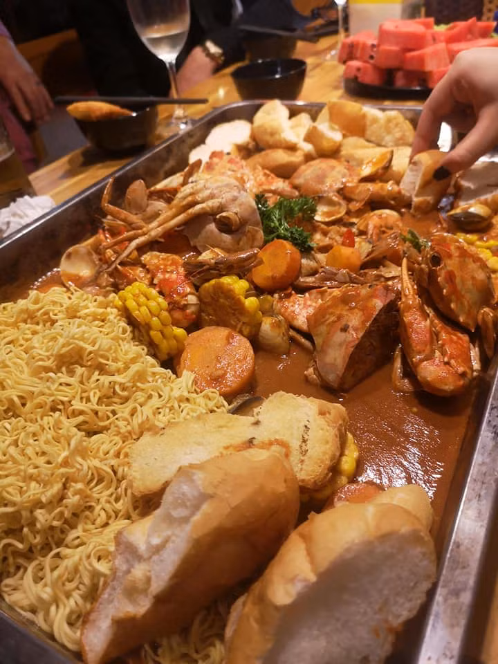 Bánh mì và mì tôm trần qua nước sôi là món ăn kèm của hải sản bốc tay này.