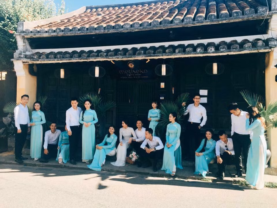 Sau khi buổi chụp hình trên biển Mỹ Khê thành công, cả ê – kíp lại di chuyển đến Hội An để tiếp tục hoàn thiện bộ ảnh cưới. Lần này MC VTV Mai Ngọc không mặc váy cưới, thay vào đó cô diện chiếc áo dài màu trắng tinh khôi phối hợp ăn í với dàn phù dâu mặc áo dài màu ngọc bích. Chú rể cùng đội nhà trai mặc áo sơ mi trắng và quần âu đen.