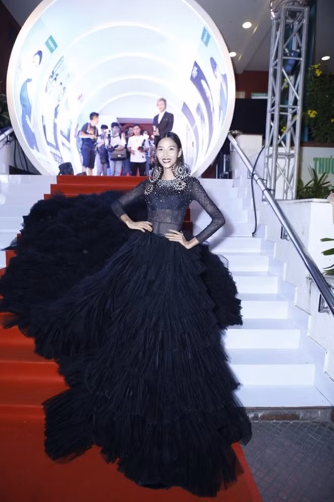 Huấn huyện viên Hoàng Thùy chơi trội với một chiếc váy đuôi cực dài.