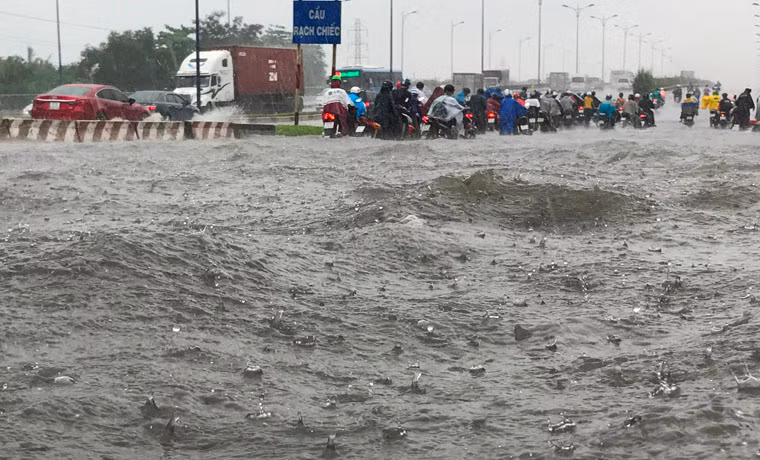 Trên xa lộ Hà Nội (đoạn 2 đầu cầu Rạch Chiếc, thuộc các quận 2, 9 và Thủ Đức), mưa gây ngập nặng gần 1m khiến xe cộ phải bì bõm lội nước.