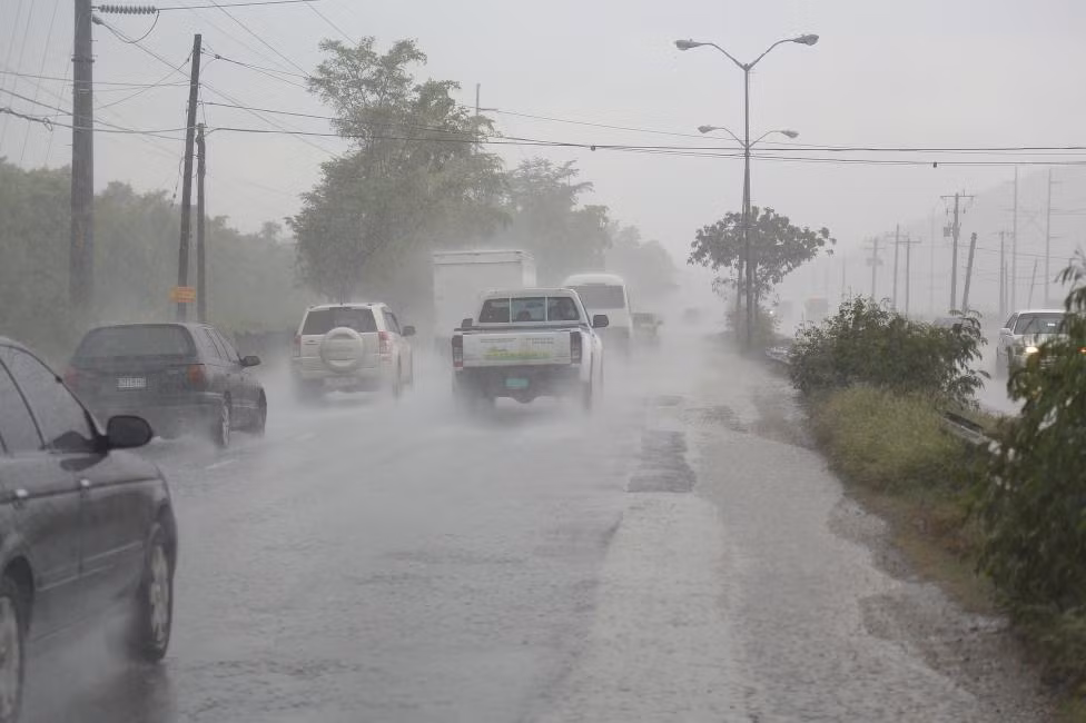 Dòng xe di chuyển chậm khi những cơn mưa to do bão Matthew gây nên trút xuống Kingston, Jamaica.