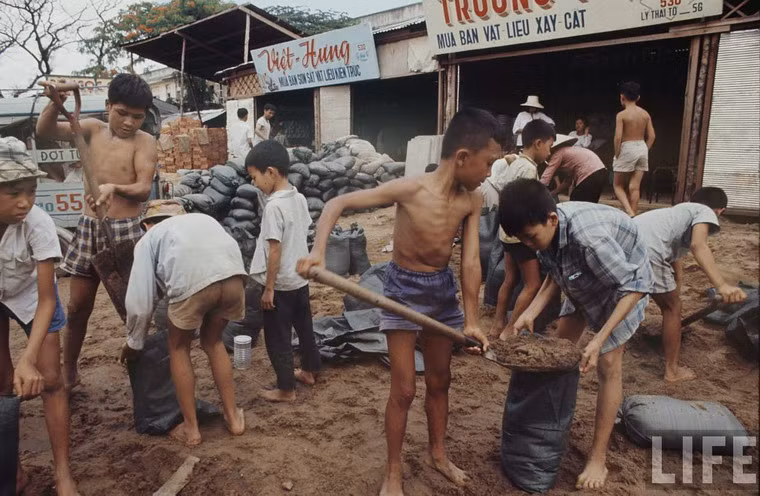 Nhân công trẻ em xúc cát vào bao tại vựa vật liệu xây dựng trên đường Lý Thái Tổ. Sau sự kiện Tết Mậu Thân 1968, nhu cầu về vật liệu xây dựng ở Sài Gòn tăng mạnh để khôi phục các công trình bị phá hủy.