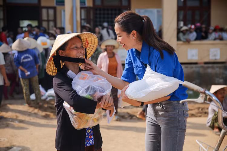 Dù khá vất vả nhưng người đẹp sinh năm 1991 luôn nở nụ cười rạng rỡ trên môi khiến bà con vùng lũ thêm ấm lòng. 